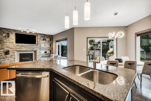 Kitchen island with granite countertops and a double stainless steel sink - 1107 Chahley Crest, Edmonton, AB 