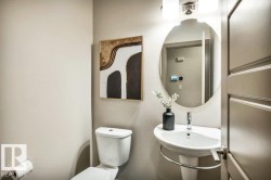 Pedestal sink with chrome faucet, oval mirror, and wall-mounted light fixture - 