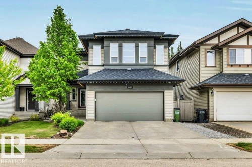 Contemporary two-story residence featuring a two-car garage, partial stone facade, and a covered porch entry - 1107 Chahley Crest, Edmonton, AB 
