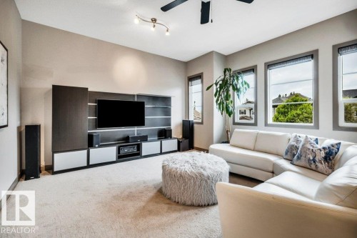 Integrated media wall with dark wood-finish paneling and built-in cabinetry - 1107 Chahley Crest, Edmonton, AB 