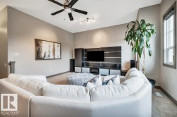 Spacious living area featuring a ceiling fan, recessed lighting, built-in entertainment center, and a large window - 