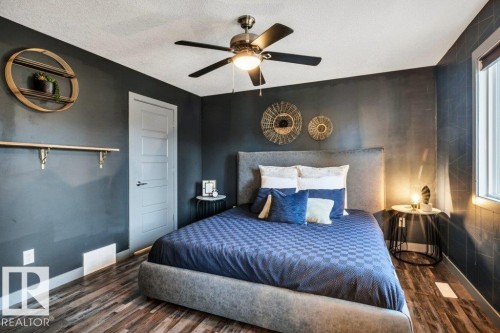 Bedroom featuring wood-finish flooring, a ceiling fan with integrated lighting, and a window with trim - 1107 Chahley Crest, Edmonton, AB 