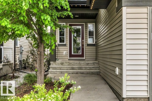Entryway featuring a dark wood-finish door with glass panels, flanked by two side windows - 1107 Chahley Crest, Edmonton, AB 