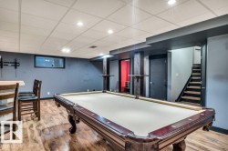 Finished basement space featuring wood-finish flooring, recessed lighting, and a drop ceiling - 