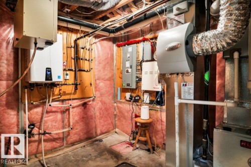 Utility area featuring a tankless water heater, comprehensive plumbing, electrical panels, ductwork, and insulation - 1107 Chahley Crest, Edmonton, AB 