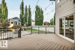 Spacious composite deck with black metal and glass panel railing - 