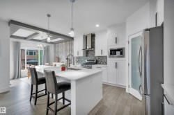 Bright kitchen featuring an expansive island with a white countertop and seating - 