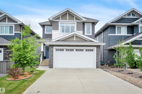 Contemporary two-story residence featuring a two-car garage, stone and siding exterior accents, a concrete driveway, and a welcoming front entrance with steps - 3898 Robins Crescent, Edmonton, AB 
