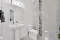 Pedestal sink with a framed mirror and overhead lighting fixture - 