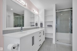 Double vanity with white cabinetry, integrated sinks, and polished chrome fixtures - 