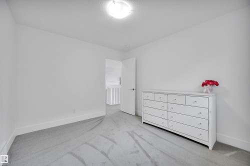 Spacious interior room featuring light gray carpeting, white baseboards, and a neutral wall palette - 3898 Robins Crescent, Edmonton, AB 