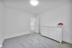 Spacious interior room featuring light gray carpeting, white baseboards, and a neutral wall palette - 