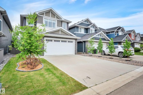 Contemporary two-story residence featuring a two-car garage with a white overhead door - 3898 Robins Crescent, Edmonton, AB 