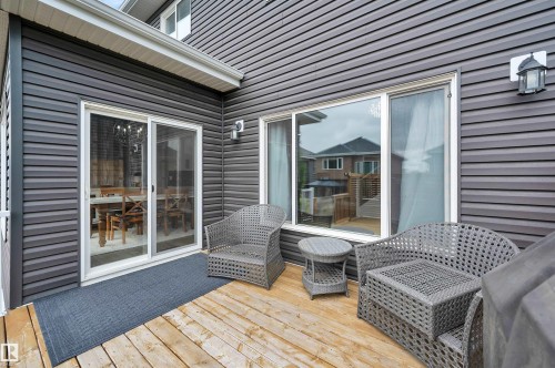 Expansive wood-finish deck featuring dark gray siding and white trim - 3898 Robins Crescent, Edmonton, AB 