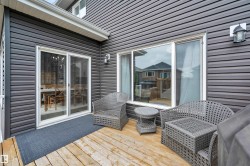 Expansive wood-finish deck featuring dark gray siding and white trim - 