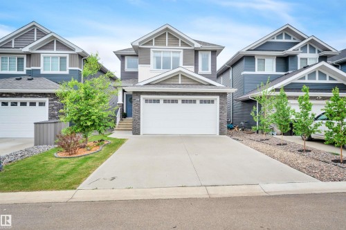 Contemporary two-story residence featuring a multi-textured facade with stone accents, horizontal siding, and gable rooflines - 3898 Robins Crescent, Edmonton, AB 