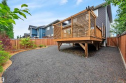 Raised wood deck featuring a slatted privacy screen and wood railing - 