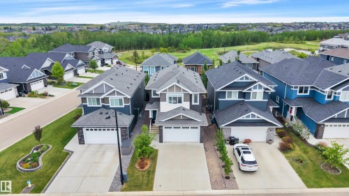 Contemporary exterior featuring a gabled roofline, stone accents, and a two-car garage - 3898 Robins Crescent, Edmonton, AB 