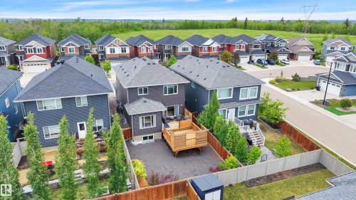 Rear exterior featuring a multi-level wood-finish deck, privacy fencing, and a manicured lawn - 3898 Robins Crescent, Edmonton, AB 