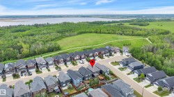 Aerial view of a residential community featuring a variety of single-family homes with dark roofs and light-colored siding - 