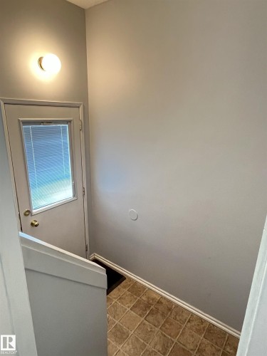 Rear entry door with integrated blinds, complemented by an overhead sconce light - 17932 93 Avenue, Edmonton, AB 