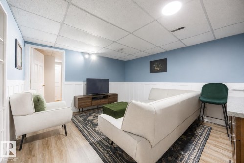 Finished room featuring wood-finish flooring, half-wall wainscoting, and recessed lighting - 17932 93 Avenue, Edmonton, AB 