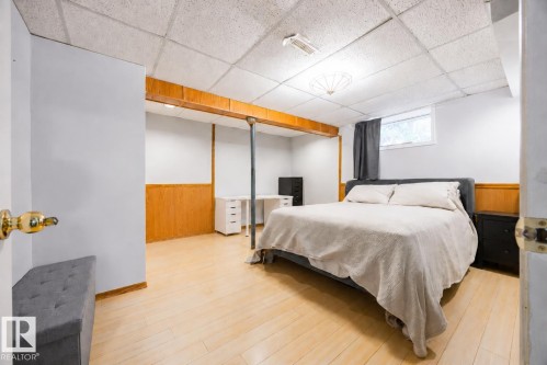 Spacious room featuring light wood-finish flooring, white walls, and wood paneling - 17932 93 Avenue, Edmonton, AB 