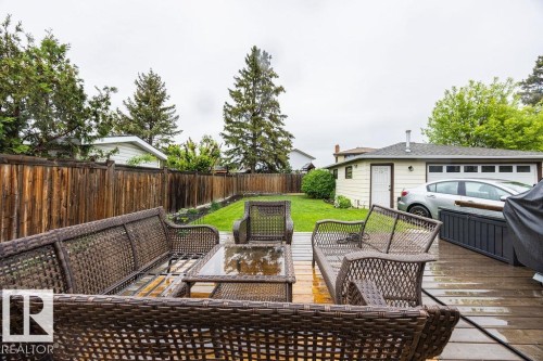 Expansive backyard featuring a wood deck, manicured lawn, and mature perimeter trees - 17932 93 Avenue, Edmonton, AB 