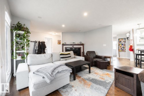 Inviting living space featuring wood-finish flooring, a fireplace with a dark wood mantel, recessed lighting, and light-toned walls - 17932 93 Avenue, Edmonton, AB 