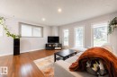 Spacious living area featuring wood-finish flooring, recessed lighting, and multiple windows with roller shades - 17932 93 Avenue, Edmonton, AB 
