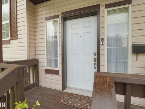 Front entry featuring a white paneled door, two sidelight windows with muntin grids, and a dark brown trim - 15511 45 Street, Edmonton, AB - Outdoor With Exterior