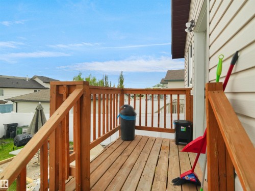 Exterior wood-finish deck featuring horizontal siding, exterior lighting, a wooden railing, and a door frame - 15511 45 Street, Edmonton, AB - Outdoor With Exterior
