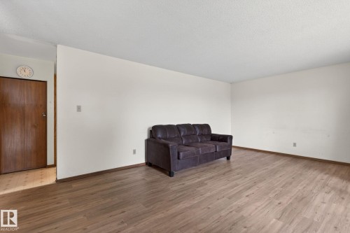 Spacious room featuring light-colored walls and wood-finish flooring - 13920 64 Street, Edmonton, AB 