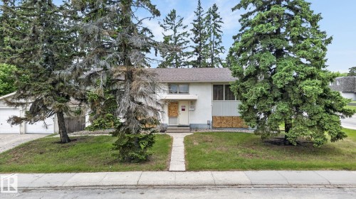 Split-level residence featuring a white stucco exterior with a stone veneer accent - 13920 64 Street, Edmonton, AB 