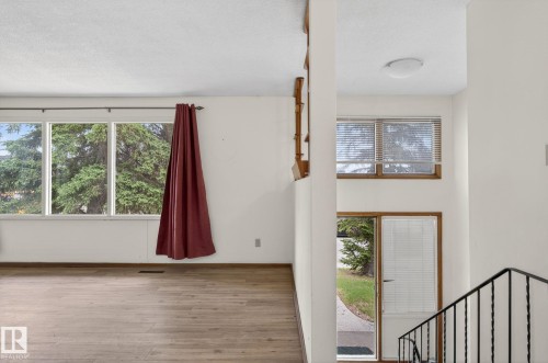 Split-level entry featuring wood-finish flooring and a multi-pane window - 13920 64 Street, Edmonton, AB 