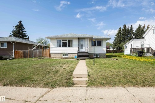 White siding exterior with a shingled roof, featuring a concrete walkway leading to the front entry - 4414 54 Avenue, Barrhead, AB - Outdoor
