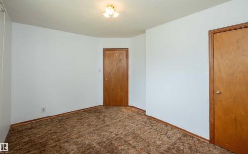 Neutral white walls with brown trim and baseboards - 4414 54 Avenue, Barrhead, AB - Indoor Photo Showing Other Room
