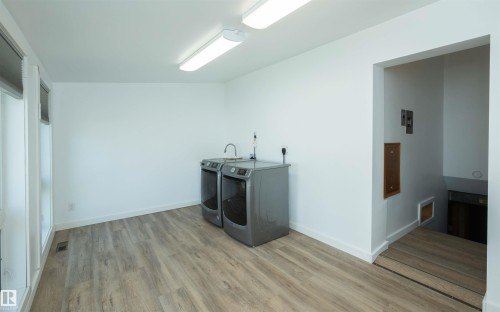 Dedicated utility area featuring wood-finish flooring, white walls, and bright overhead lighting - 4414 54 Avenue, Barrhead, AB - Indoor Photo Showing Laundry Room