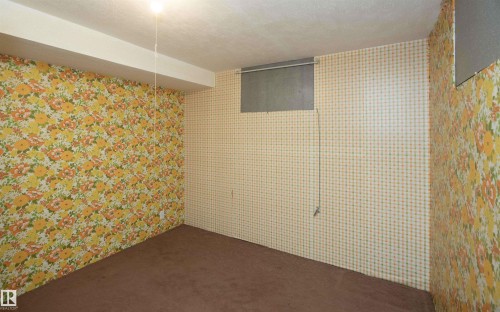 Lower level room featuring patterned wallpaper, carpet flooring, a drop ceiling, and a recessed window - 4414 54 Avenue, Barrhead, AB - Indoor Photo Showing Other Room