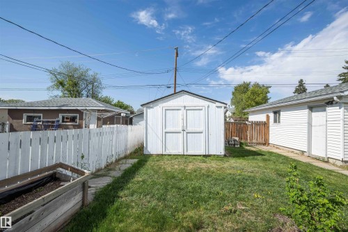 Expansive grassy area featuring a white storage shed and perimeter fencing - 4414 54 Avenue, Barrhead, AB - Outdoor