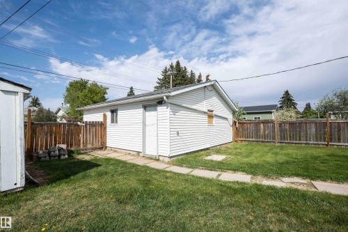 Detached garage featuring white siding, a side entry door, and a single window - 4414 54 Avenue, Barrhead, AB - Outdoor