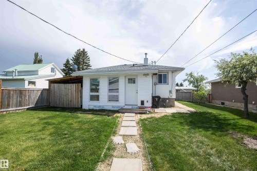 White exterior with a shingled roof and a stone pathway leading to the entrance - 4414 54 Avenue, Barrhead, AB - Outdoor