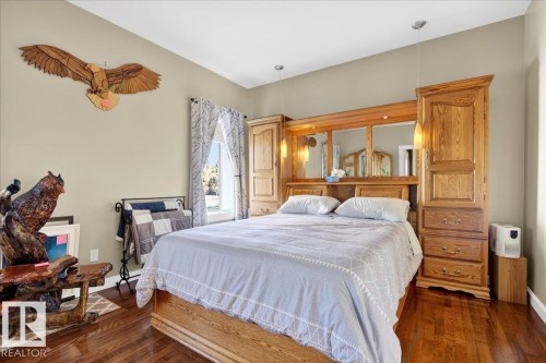 Hardwood flooring complements a neutral wall color - 5019 48 Avenue, Chipman, AB - Indoor Photo Showing Bedroom