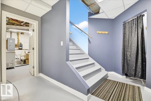 Staircase with wood handrail and light gray treads - 5019 48 Avenue, Chipman, AB - Indoor Photo Showing Other Room