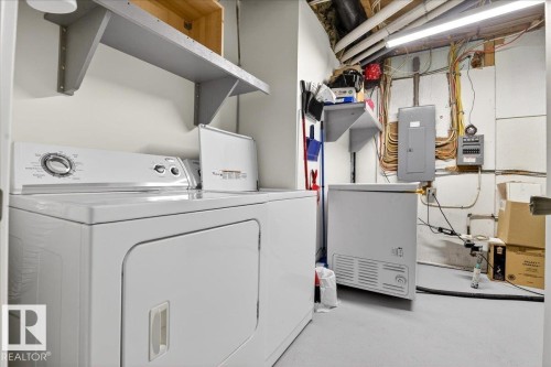 Utility area featuring a washer and dryer, painted concrete flooring, and an exposed ceiling with lighting - 5019 48 Avenue, Chipman, AB - Indoor Photo Showing Laundry Room