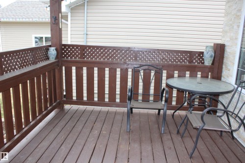 Spacious outdoor deck featuring wood flooring and a sturdy wood railing with decorative lattice accents - 5019 48 Avenue, Chipman, AB - Outdoor With Deck Patio Veranda With Exterior