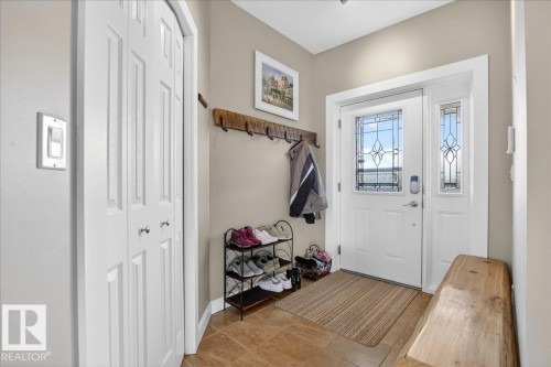 Entryway featuring a white door with decorative glass inserts, a matching sidelight, and ceramic tile flooring - 5019 48 Avenue, Chipman, AB - Indoor Photo Showing Other Room
