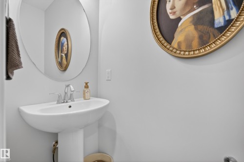 White pedestal sink with a chrome two-handle faucet and an oval mirror - 22836 94 Avenue, Edmonton, AB 