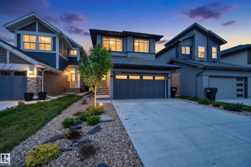 Contemporary exterior featuring a two-car garage, concrete driveway, and stone accents - 22836 94 Avenue, Edmonton, AB 
