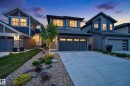 Contemporary exterior featuring a two-car garage, concrete driveway, and stone accents - 22836 94 Avenue, Edmonton, AB 